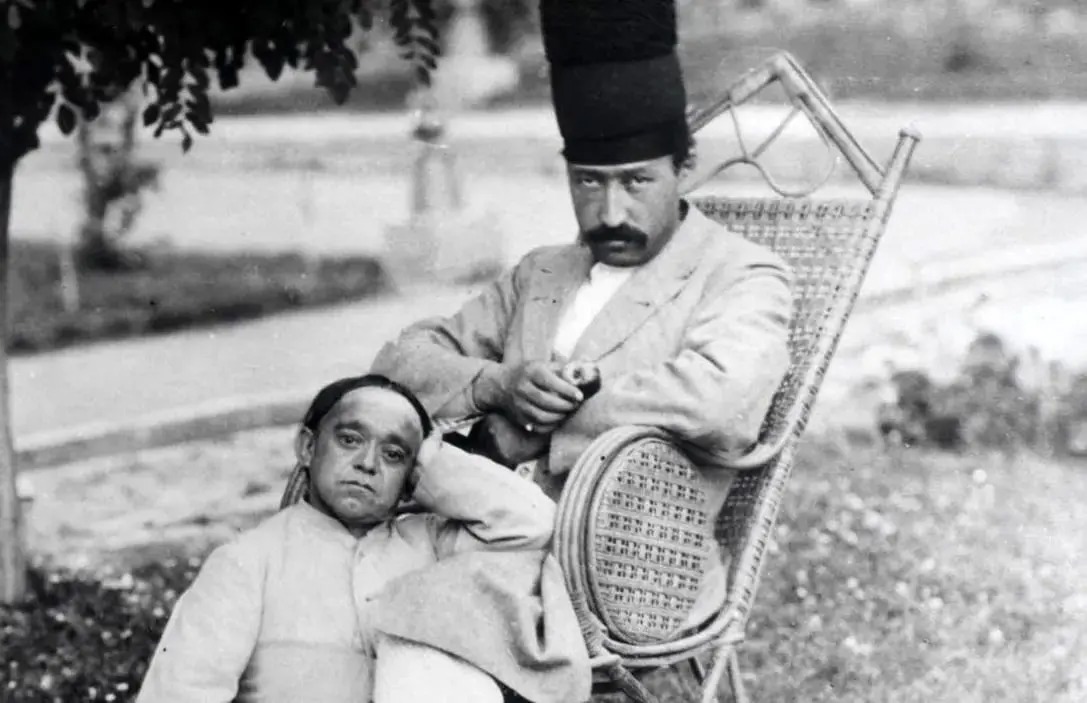 سفر در زمان؛ تصویر رنگی‌شده از مرد قاجاری با کلاه پنج‌طبقه در کنار یک خواجه