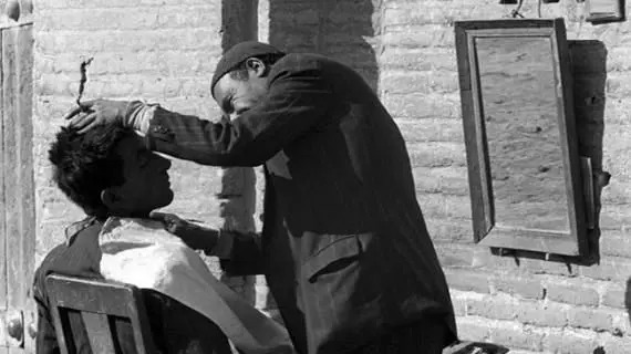 سفر در زمان؛ تراشیدن موهای پسربچۀ تهرانی در کنار خیابان؛ ۹۹ سال قبل